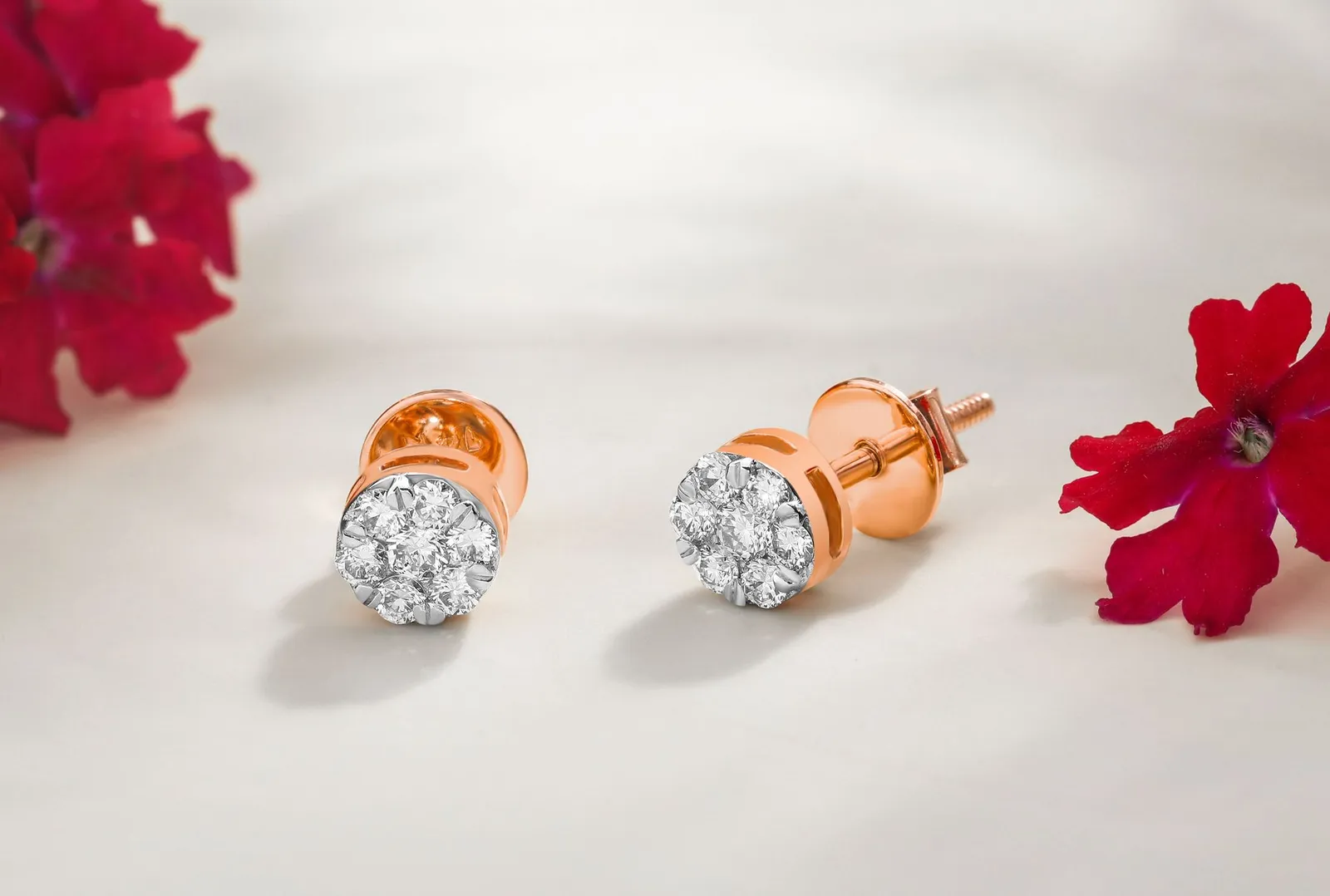 A pair of rose gold stud earrings with screw backs