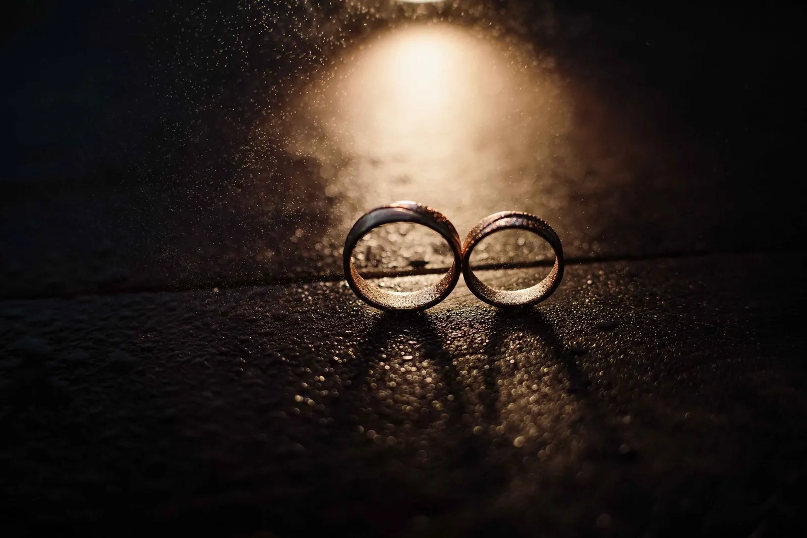 A pair of wedding bands under a beam of light