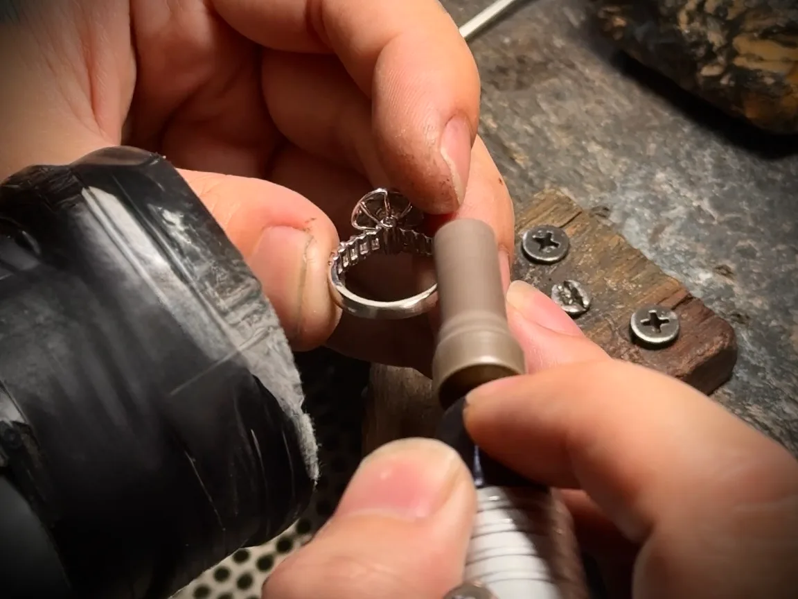A craftsman polishing a ring with a rotary tool